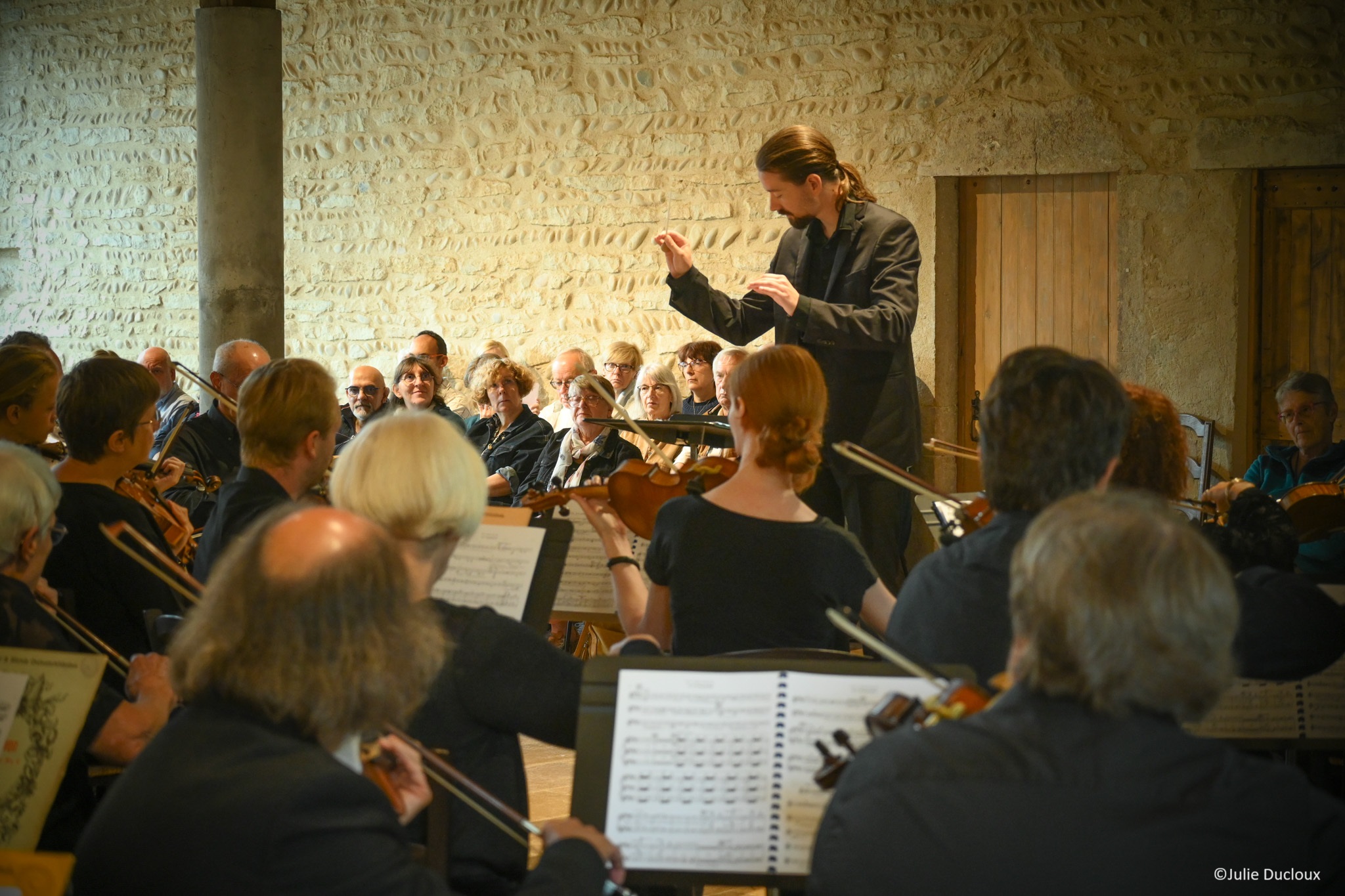 Vue de l'orchestre de dos avec Jean-Baptiste Vandevoghel à la direction - photo Julie Dulcoux